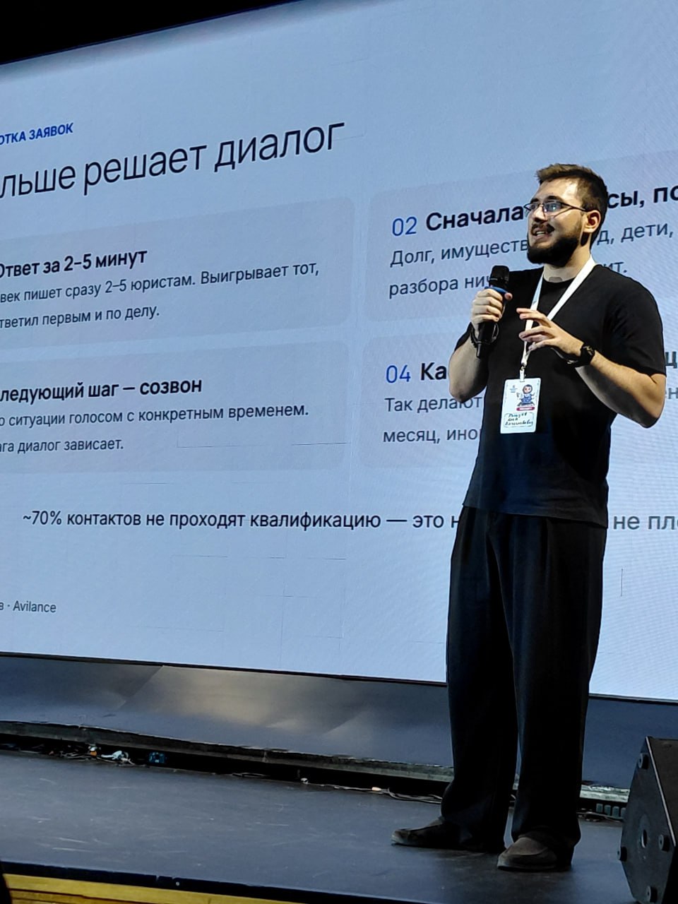 Спикер с микрофоном перед презентацией о работе с обращениями клиентов